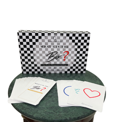 Geöffnete Box mit Schachbrettdesign und mehreren Karten auf grünem Untergrund