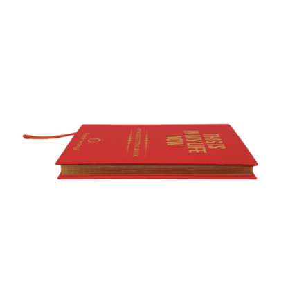 Rotes Manifestationsbuch mit goldener Typografie und orangefarbenem Band